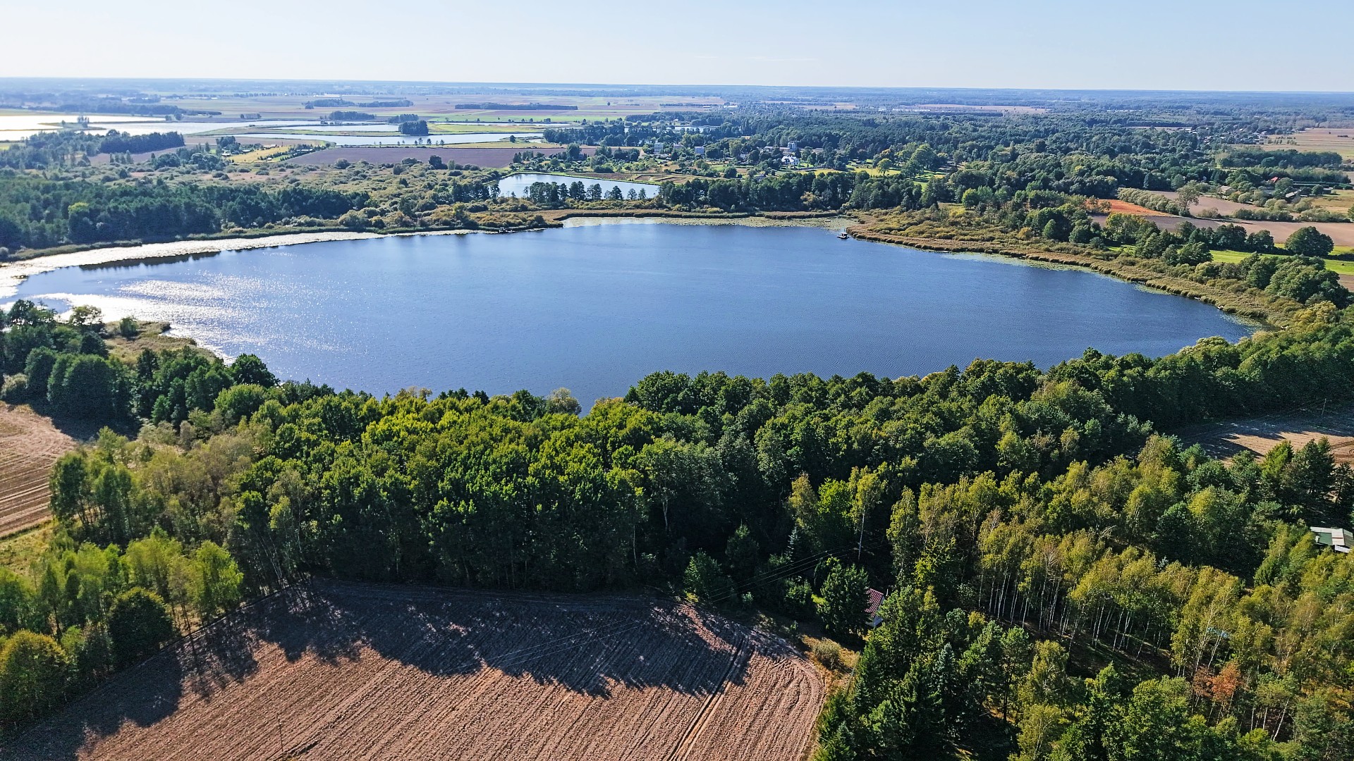 Jezioro otoczone lasem, widok z lotu ptaka.