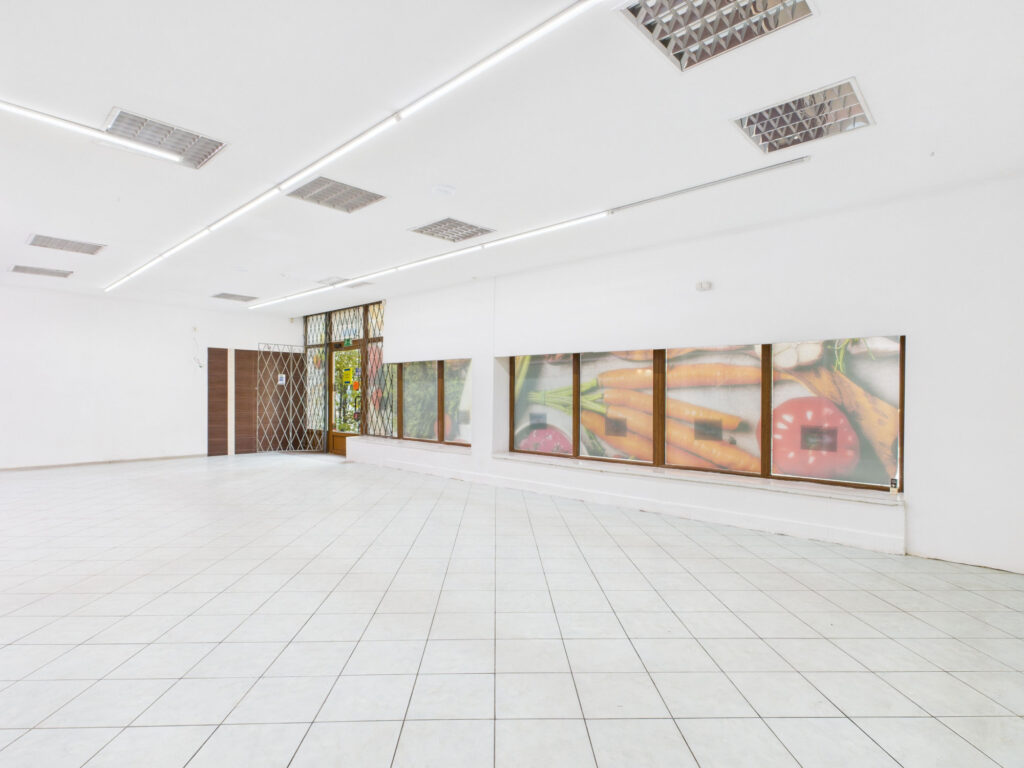 Puste wnętrze lokalu z witrynami i grafiką warzyw