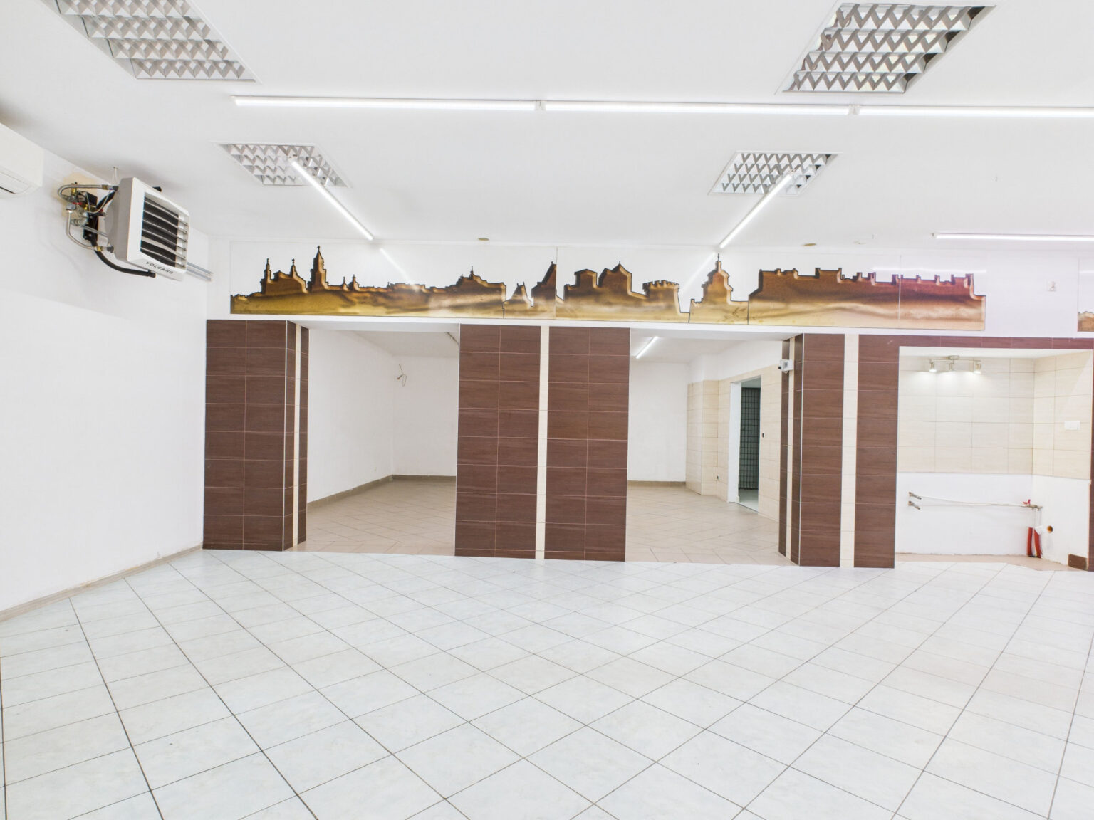 Puste wnętrze lokalu użytkowego z dekoracyjną panoramą miasta