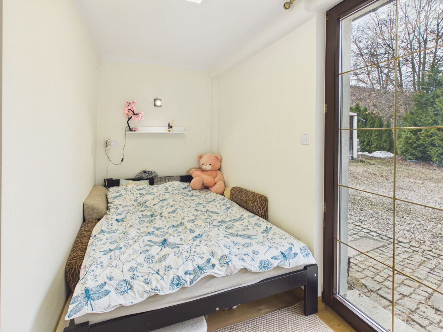 Mała sypialnia z łóżkiem i misiem pluszowym