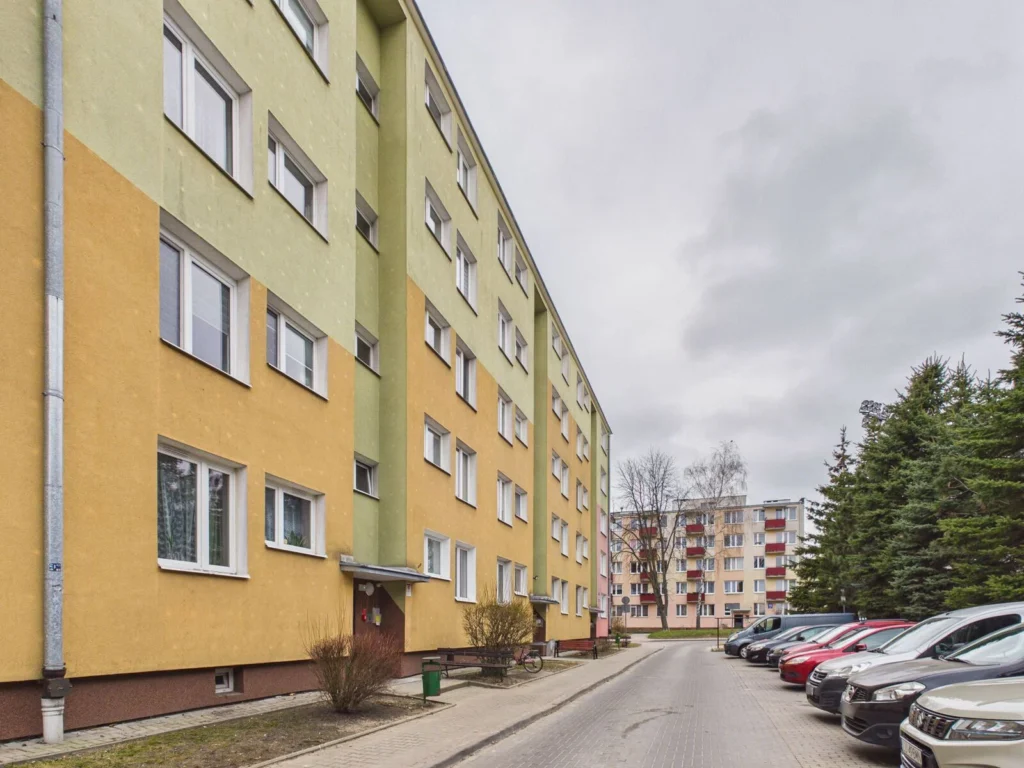 Blok mieszkalny z zaparkowanymi samochodami