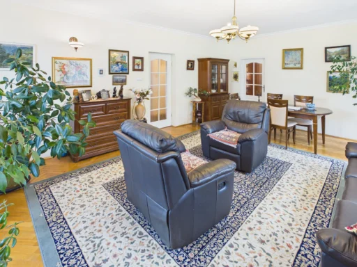 Elegancki salon z skórzanymi fotelami i drewnianymi meblami