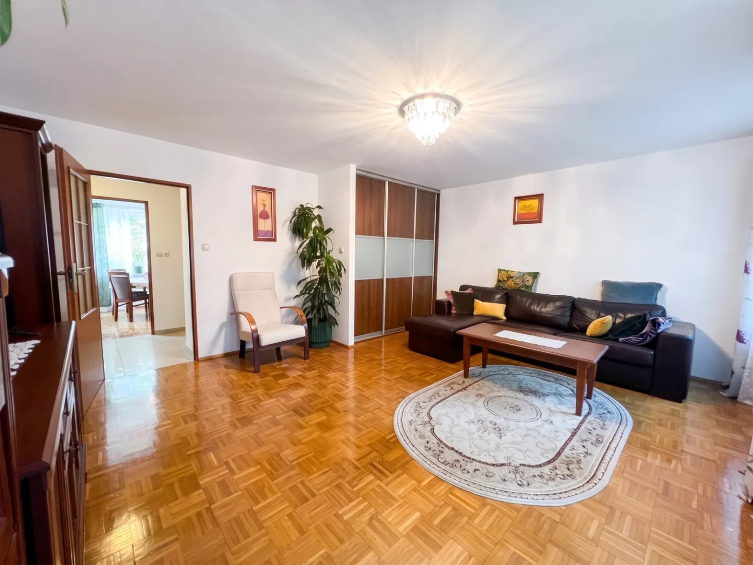 Jasny salon z narożnikiem i parkietem