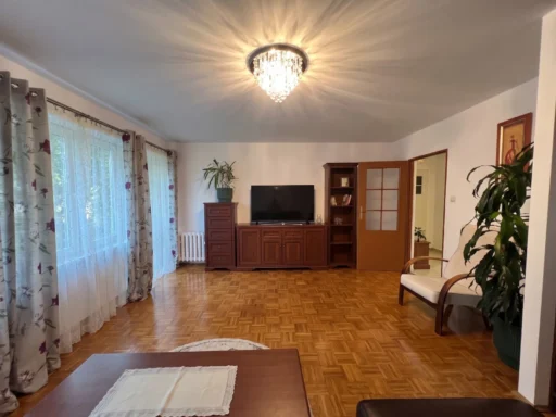Przestronny salon z parkietem i drewnianymi meblami