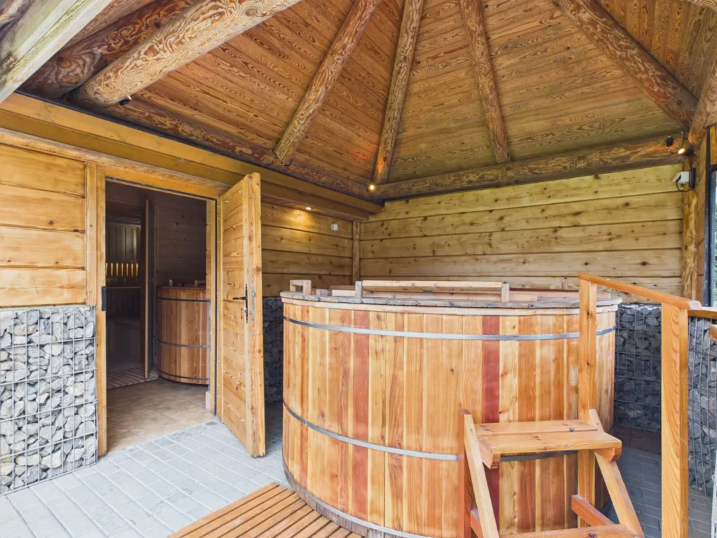 Drewniana sauna z balią ogrodową pod zadaszeniem