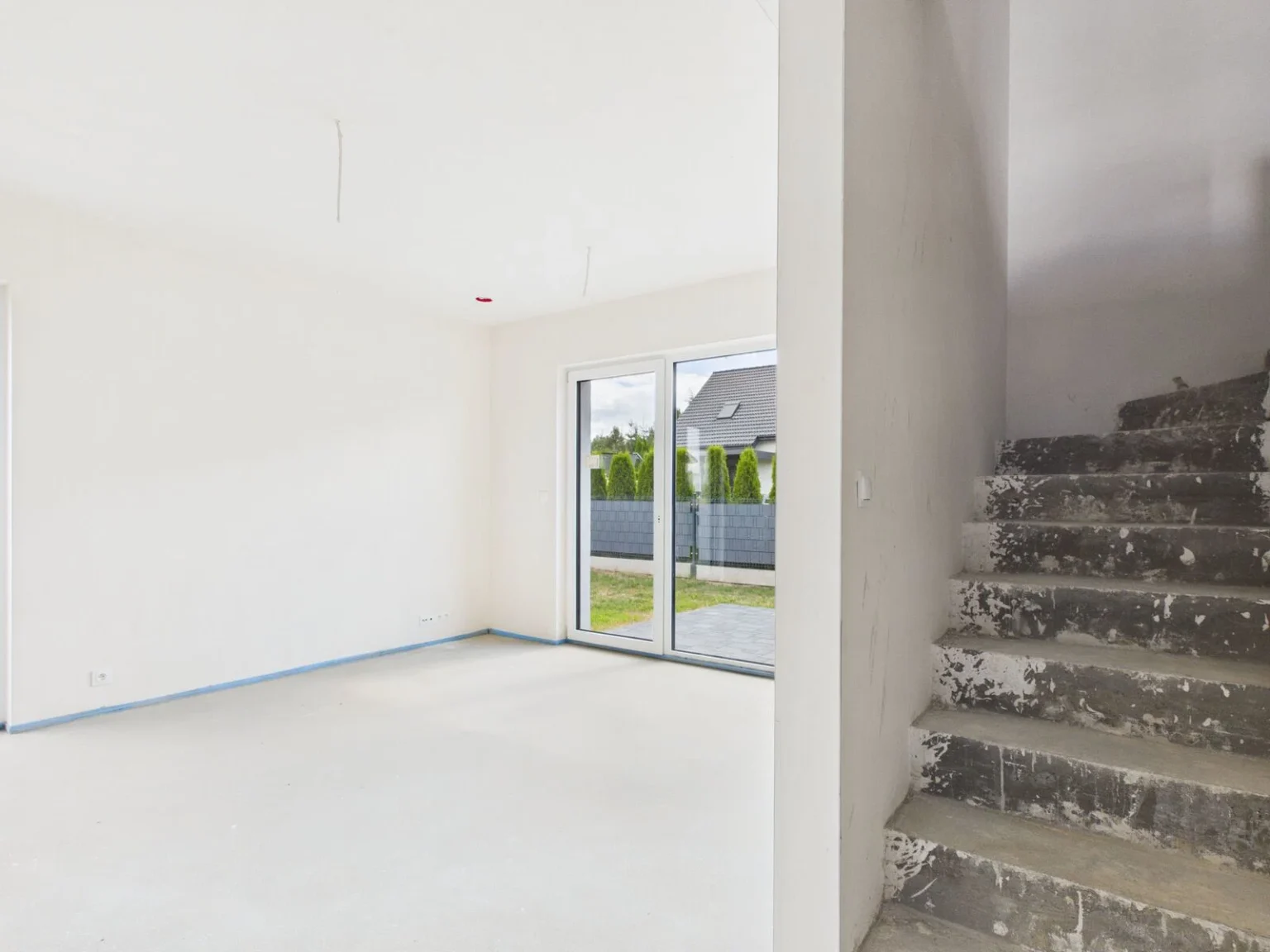 Puste wnętrze domu z betonowymi schodami