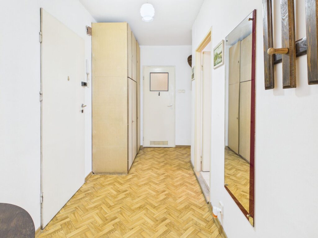 Jasny przedpokój z szafą, lustrem i parkietem