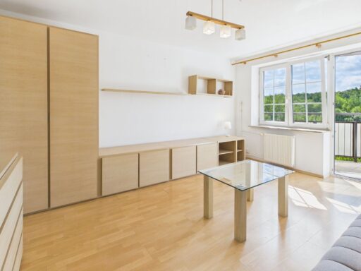 Jasny salon z drewnianą zabudową i balkonem