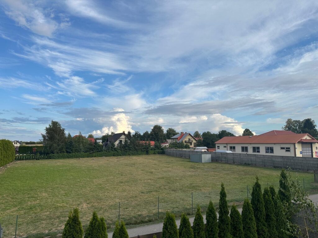 Osiedle domów z rozległym niebem i pierzastymi chmurami