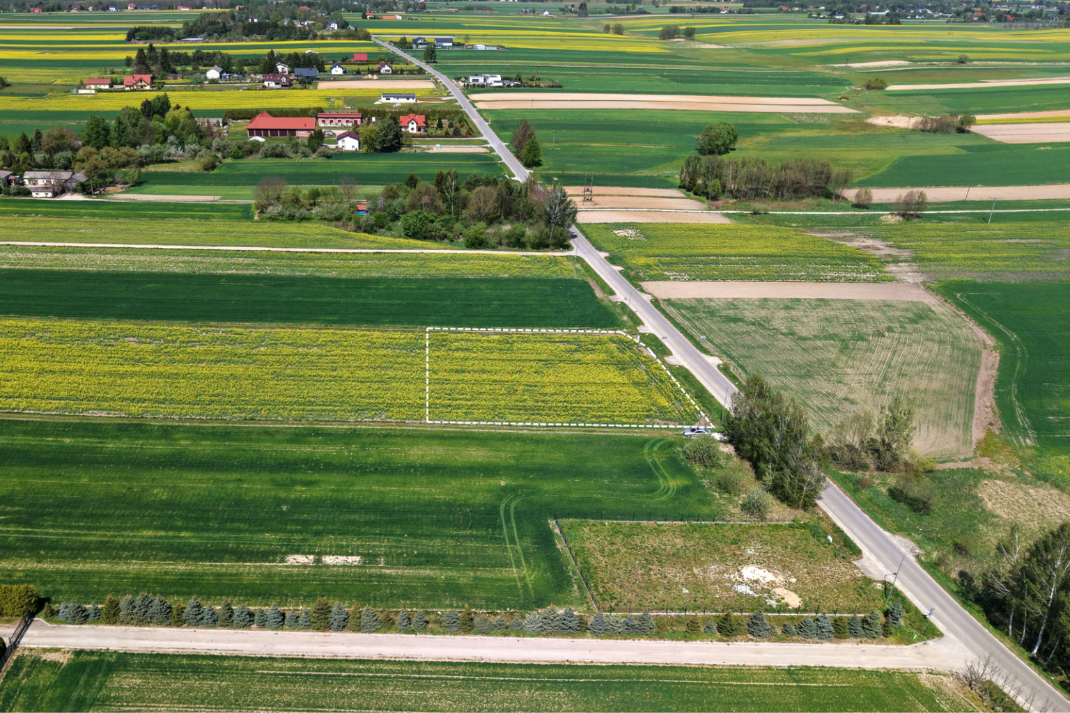 Widok z lotu ptaka na działkę wśród pól