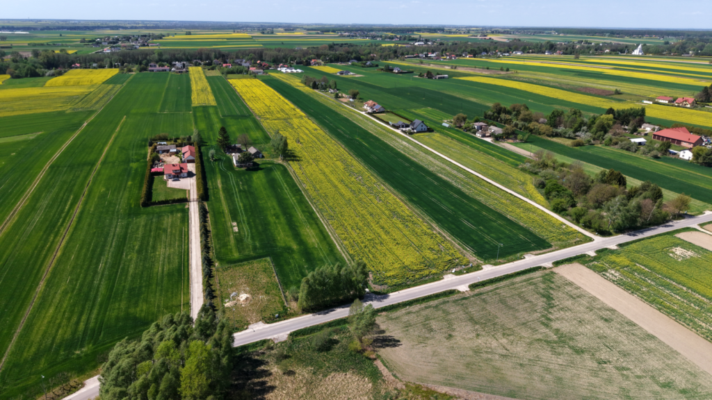 Widok z lotu ptaka na pola i wiejską zabudowę